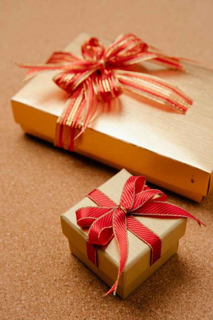 Elegant wrapped gift boxes in gold with red ribbons, perfect for festive occasions and celebrations.